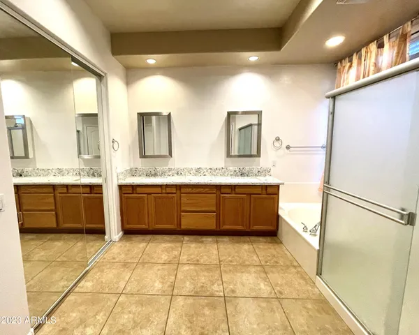 a large bathroom with a large mirror vanity sink and a toilet