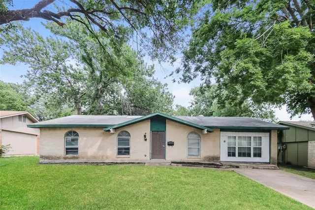 a front view of house with a garden