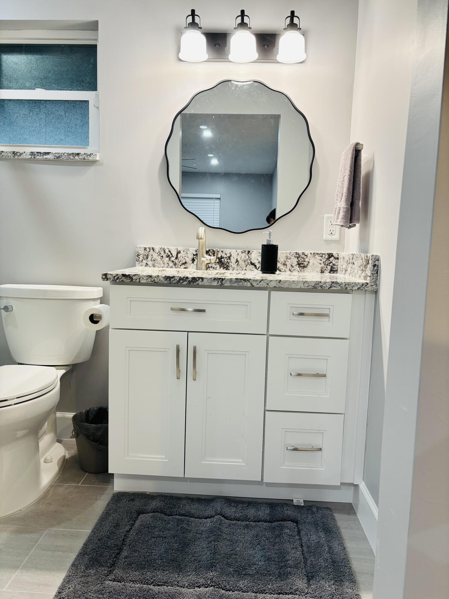 222 Southeast 3rd Street Boynton Beach, FL 33435 - Photo 13 of 40 a bathroom with a sink and a mirror