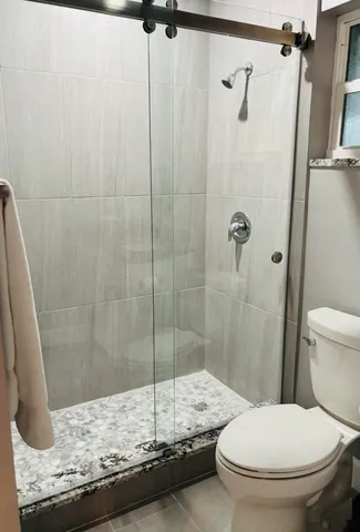 a bathroom with a granite countertop sink toilet and shower