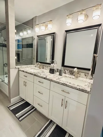 a bathroom with a granite countertop sink and a mirror
