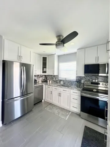 a kitchen with granite countertop stainless steel appliances and wooden cabinets