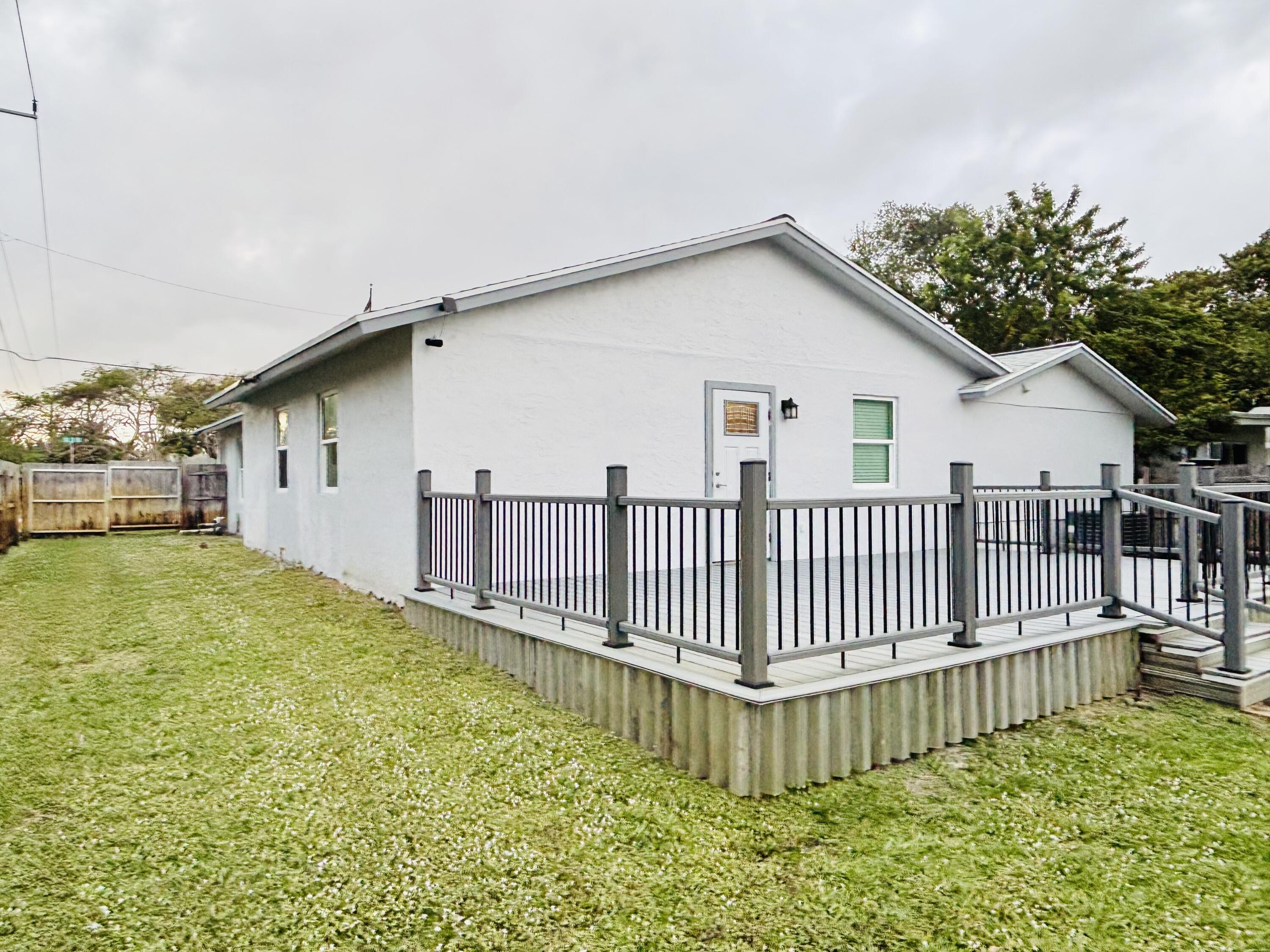 222 Southeast 3rd Street Boynton Beach, FL 33435 - Photo 31 of 40 a view of a house with wooden deck and a backyard