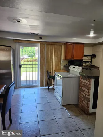a living room with lots of furniture a window and kitchen view