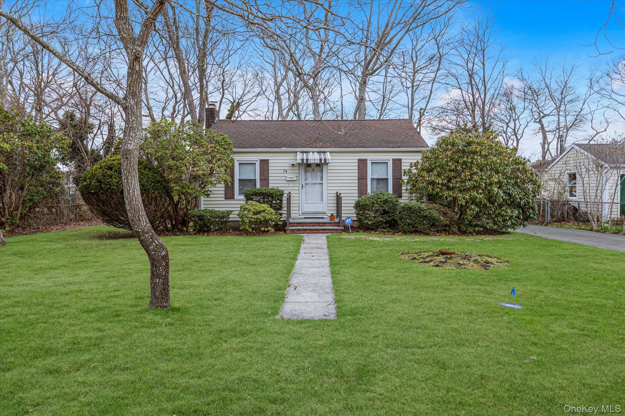 74 Country Club Road Bellport, NY 11713 - Photo 1 of 21 a front view of house with yard and green space
