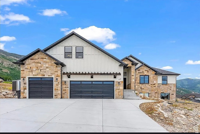 Contemporary stone and board-and-batten exterior with a two-car garage