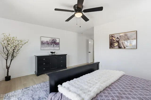 a bedroom with a bed and a painting on the wall