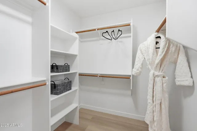 a view of walk in closet with clothes and shoes