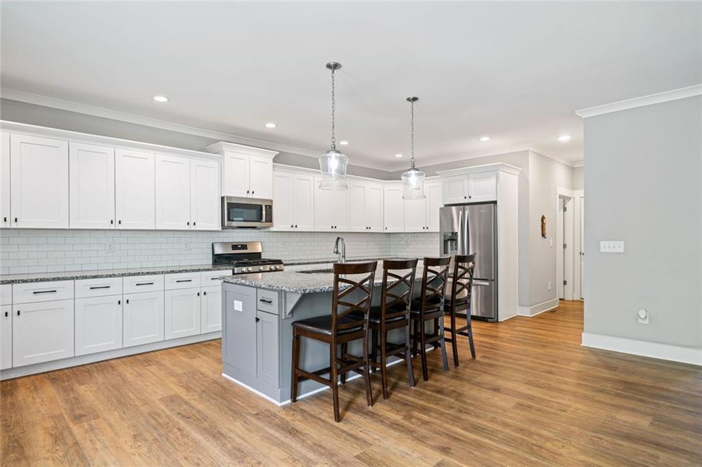 2 Village Ridge Jasper, GA 30143 - Photo 18 of 45 a kitchen with stainless steel appliances granite countertop a stove top oven a refrigerator a sink and a dining table with wooden floor