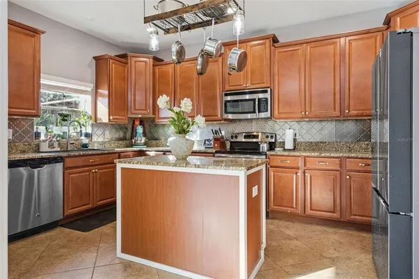 a kitchen with stainless steel appliances granite countertop a stove a sink and a microwave