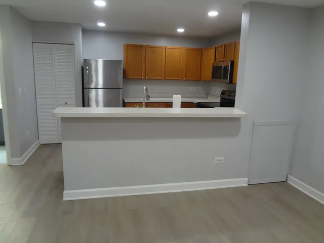 a kitchen with stainless steel appliances granite countertop a refrigerator a sink and a stove