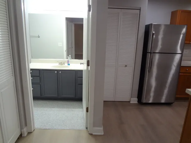 a view of a kitchen with a refrigerator and wooden floor