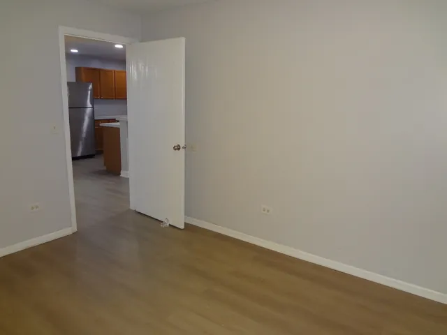 a view of a room with wooden floor and a ceiling fan