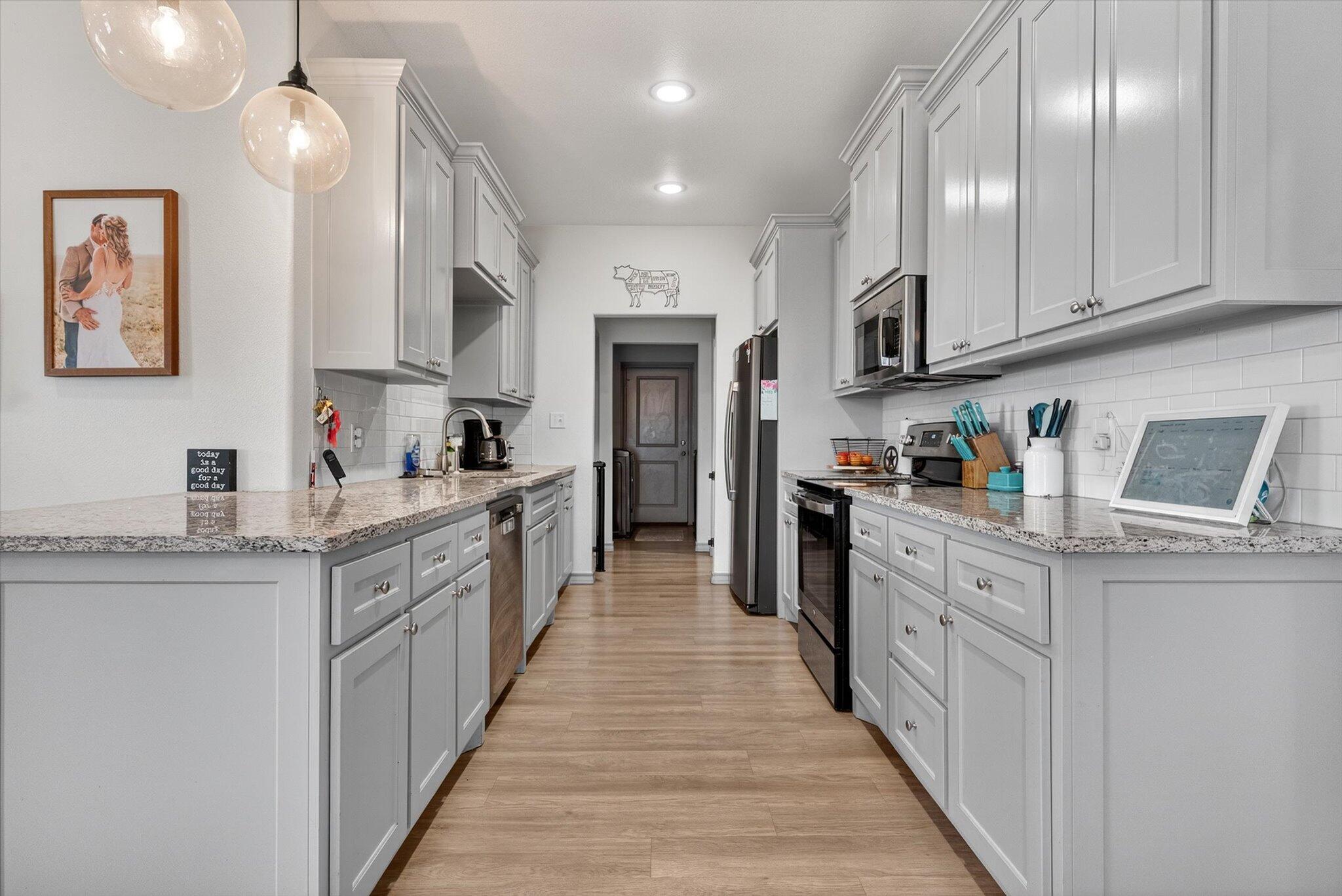 187 Allison Road Wilson, TX 79381 - Photo 11 of 35 a large kitchen with stainless steel appliances granite countertop lots of counter top space and wooden floor