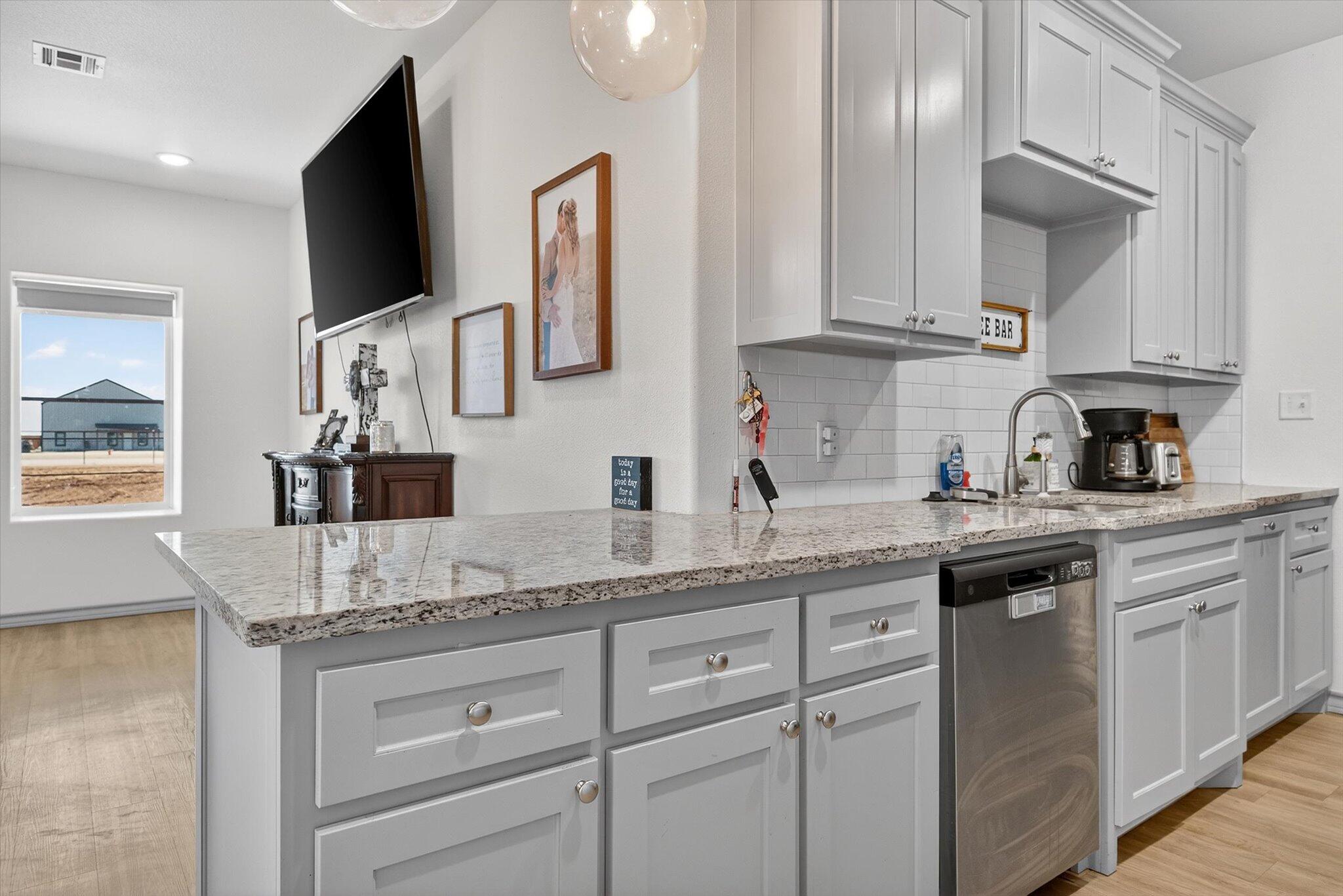 187 Allison Road Wilson, TX 79381 - Photo 13 of 35 a kitchen with granite countertop a sink stainless steel appliances and cabinets