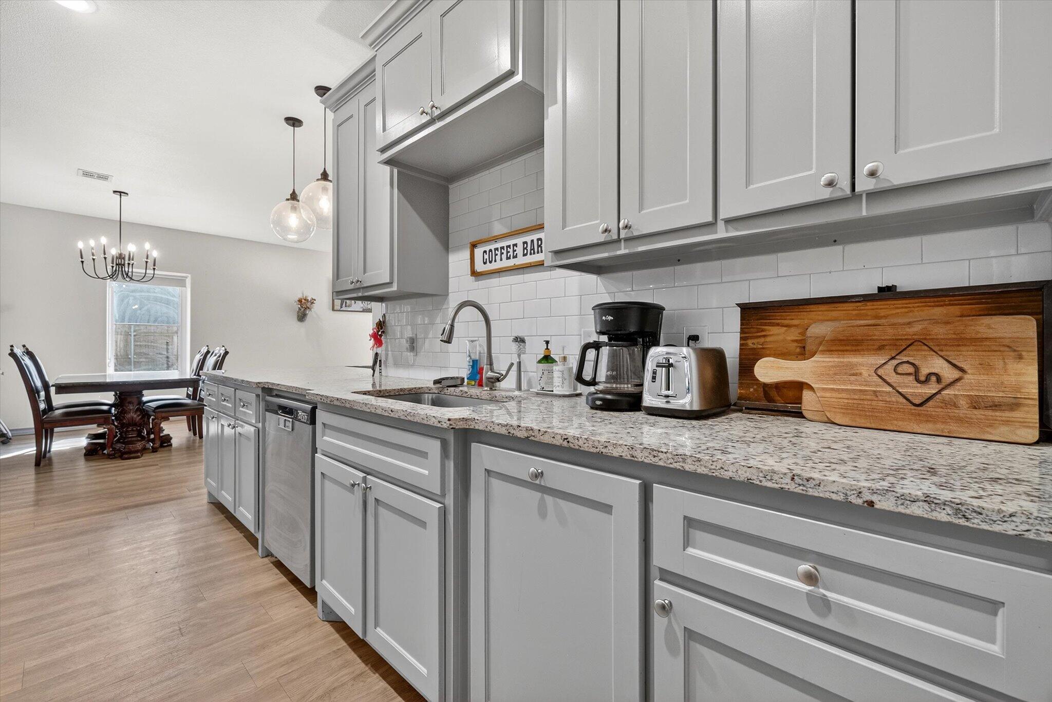 187 Allison Road Wilson, TX 79381 - Photo 14 of 35 a kitchen with stainless steel appliances granite countertop a sink dishwasher and cabinets with wooden floor
