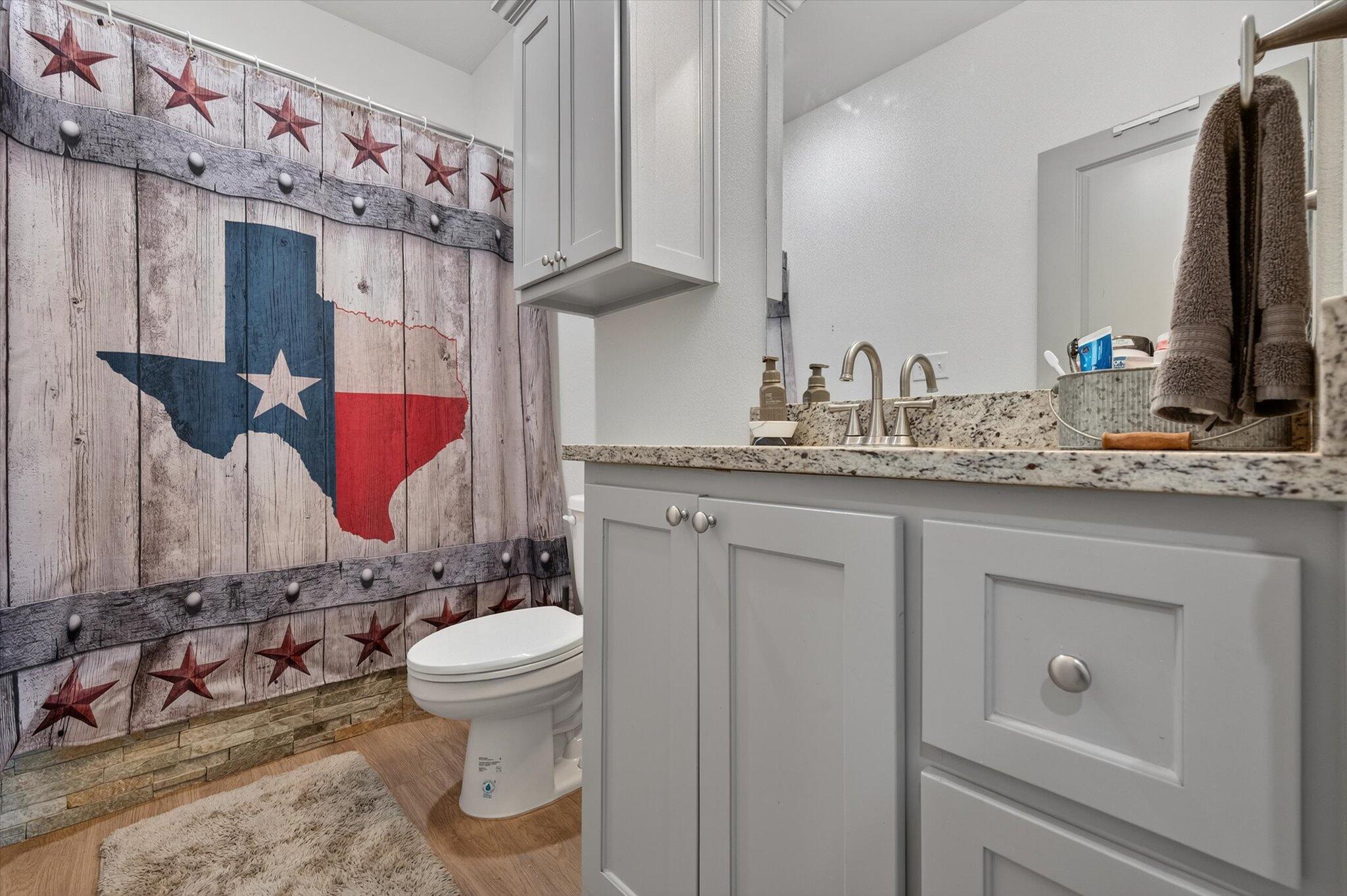 187 Allison Road Wilson, TX 79381 - Photo 25 of 35 a bathroom with a granite countertop sink and a mirror