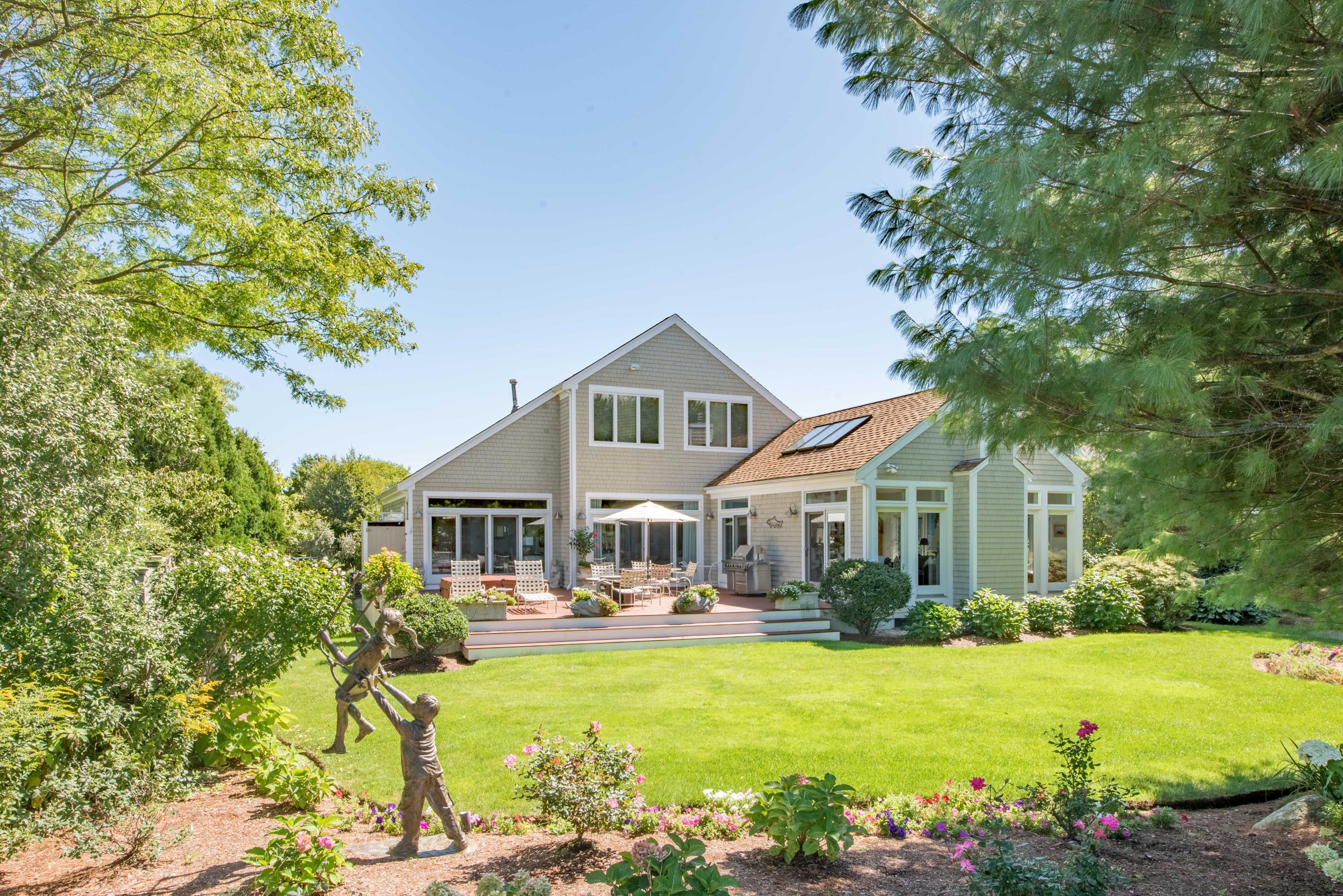 a front view of a house with swimming pool and porch with furniture