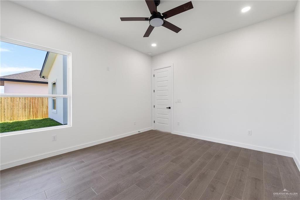 505 Freedom Way Weslaco, TX 78596 - Photo 17 of 20 an empty room with a window and a ceiling fan