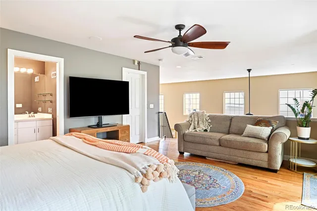 a bedroom with a bed a couch and a flat screen tv