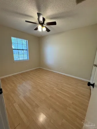 an empty room with windows and fan
