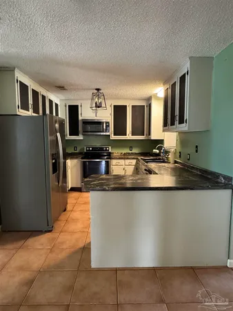 a kitchen with stainless steel appliances granite countertop a refrigerator a stove a sink a microwave and a refrigerator