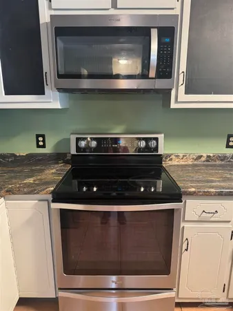 a stove top oven sitting inside of a kitchen