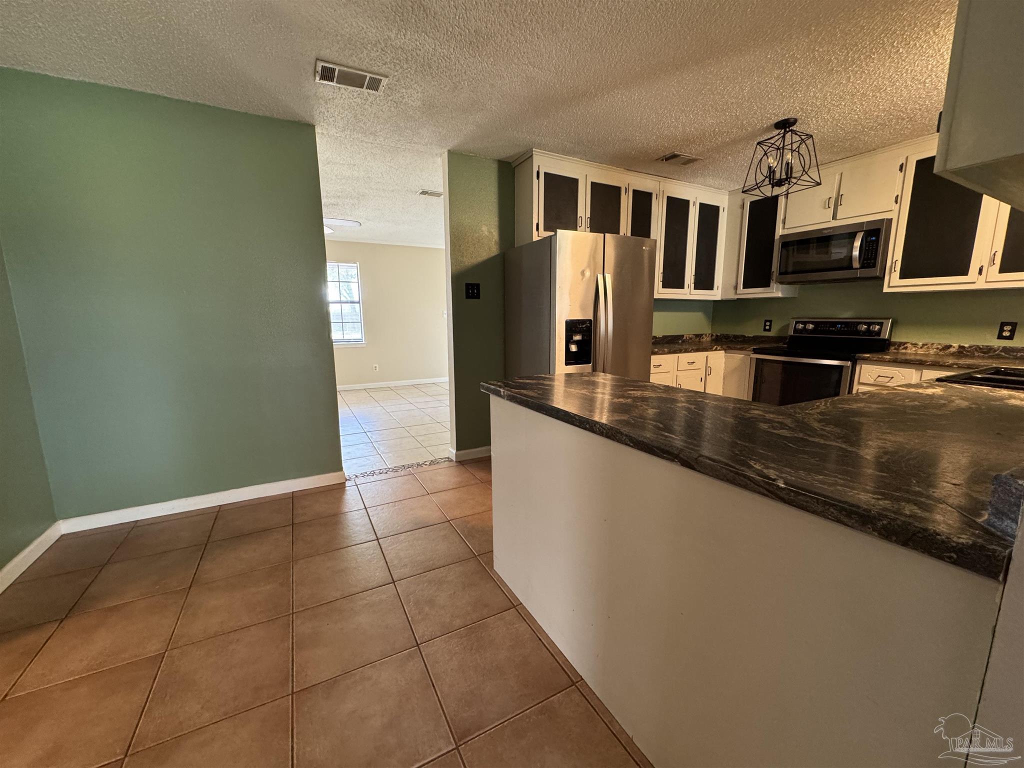 4400 Mundy Lane Pace, FL 32571 - Photo 4 of 23 a kitchen with granite countertop a refrigerator and a stove top oven