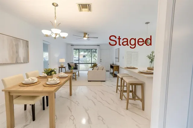 a view of a dining room with furniture a chandelier and wooden floor
