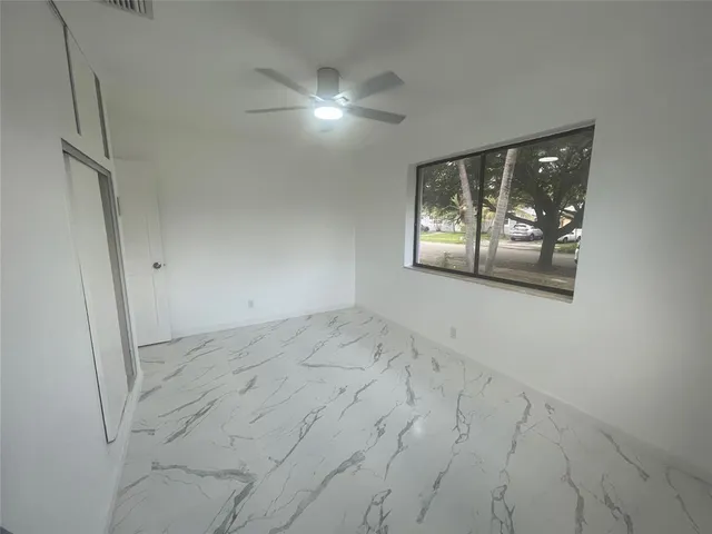 an empty room with windows and closet