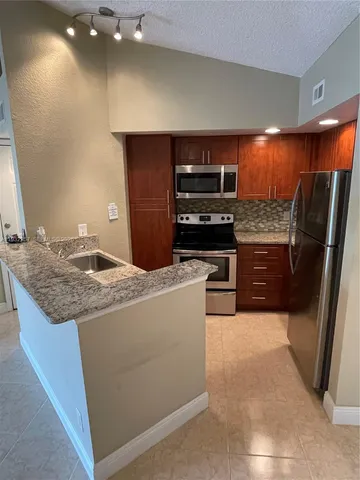 a kitchen with a refrigerator and a sink