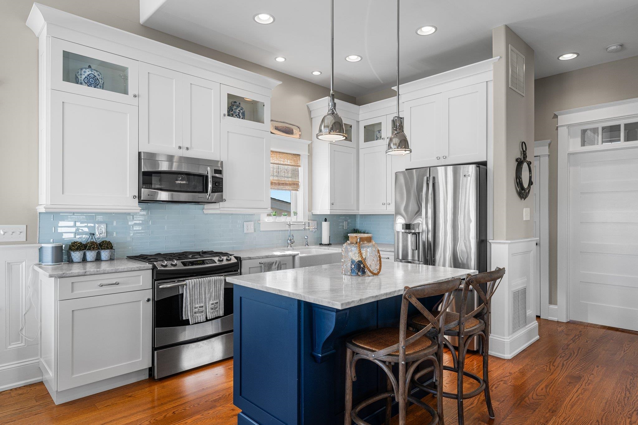 243 110th Street Stone Harbor, NJ 08247 - Photo 23 of 34 a kitchen with stainless steel appliances a stove a sink dishwasher a refrigerator white cabinets and wooden floor