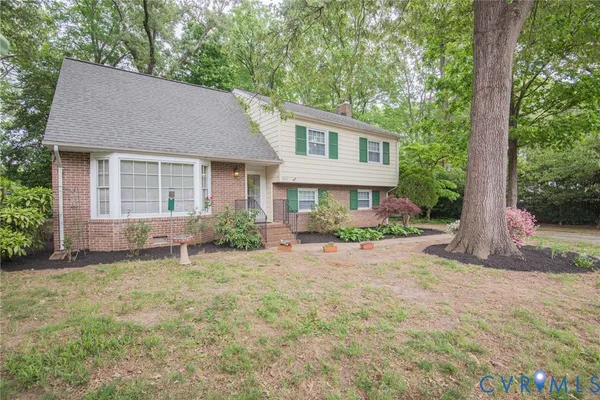 a front view of a house with a yard and trees
