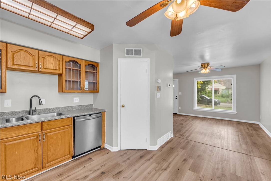 18517 Homeway Road Cleveland, OH 44135 - Photo 12 of 29 Kitchen area featuring wood cabinetry, a double basin sink with a gooseneck faucet, a stainless steel dishwasher, and a grey countertop