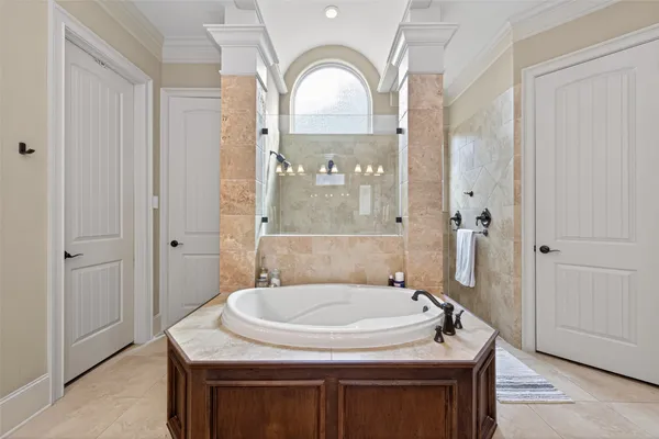 a large bathroom with a tub a double vanity sink and a large mirror