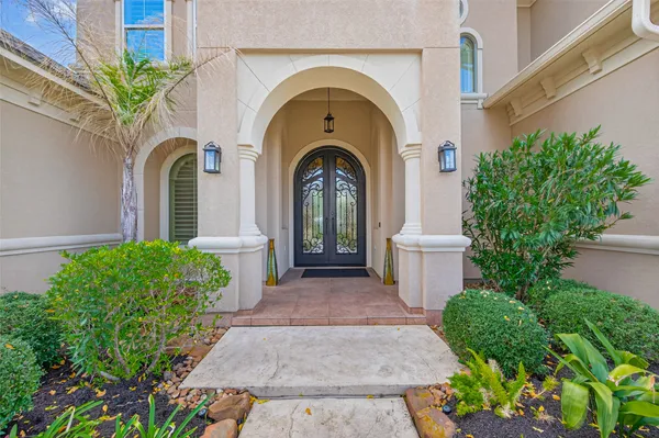 a view of a grey house with potted plants
