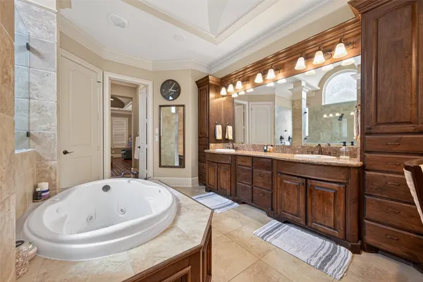 a bathroom with a tub a sink and a mirror