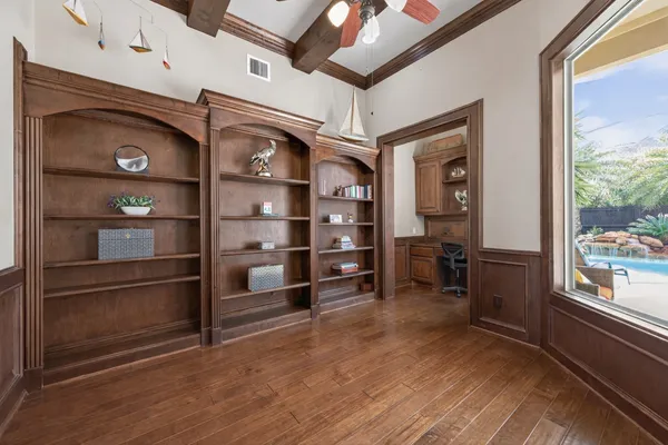a view of a hallway with a chair and wooden floor