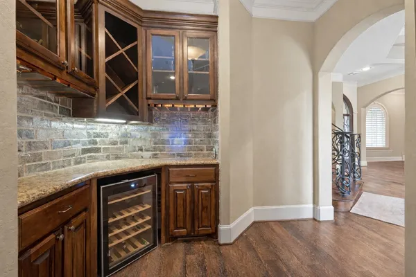 a kitchen with stainless steel appliances kitchen island granite countertop a refrigerator a stove a sink and a dining table with wooden floor