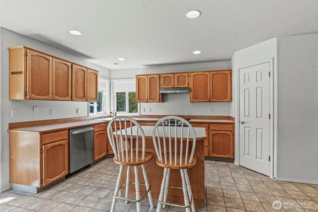 a kitchen with a table chairs sink and cabinets
