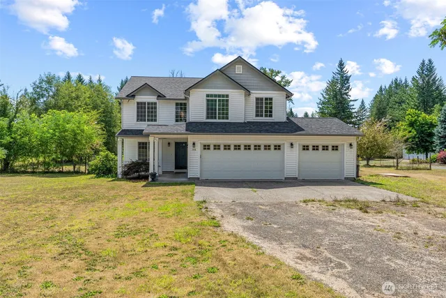 a view of a house with a yard and potted plants