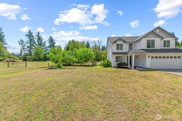 a front view of a house with a yard and trees