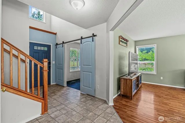 a view of hallway with stairs and wooden floor