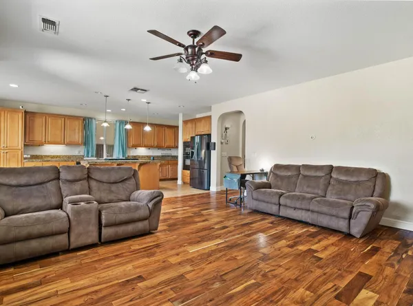 a living room with furniture and a view of kitchen