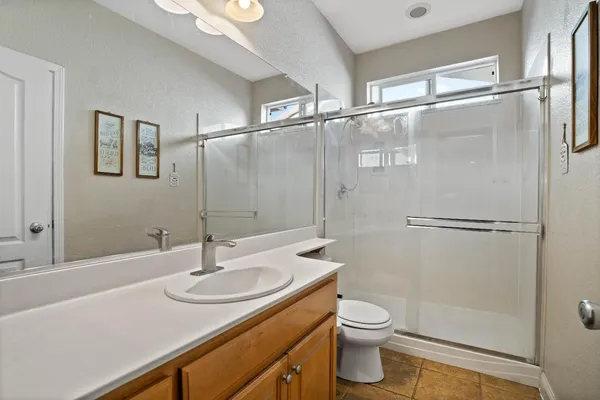 a bathroom with a granite countertop sink toilet and shower