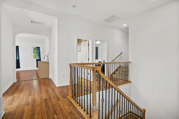 a view of a hallway with wooden floor and stairs