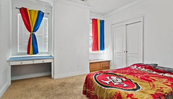 a bedroom with a bed and a painting on the wall
