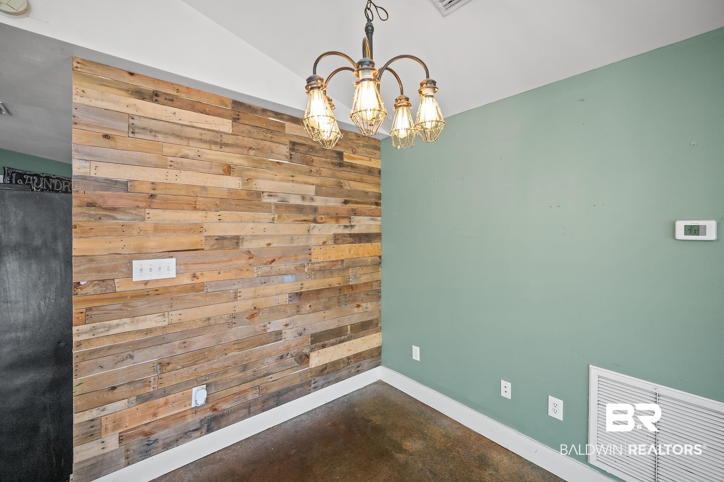 2000 Maria Lane Lillian, AL 36549 - Photo 7 of 35 Unfurnished dining area with a chandelier, wooden walls, concrete floors, and vaulted ceiling