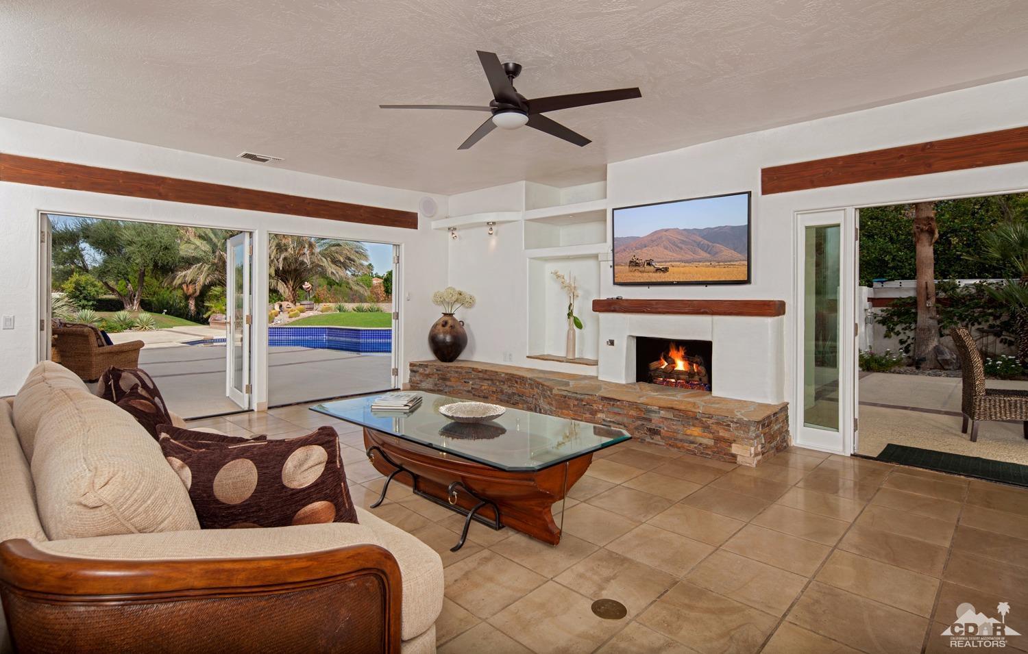 2 Vista Santa Rosa Rancho Mirage, CA 92270 - Photo 26 of 60 a living room with furniture a fireplace and a floor to ceiling window