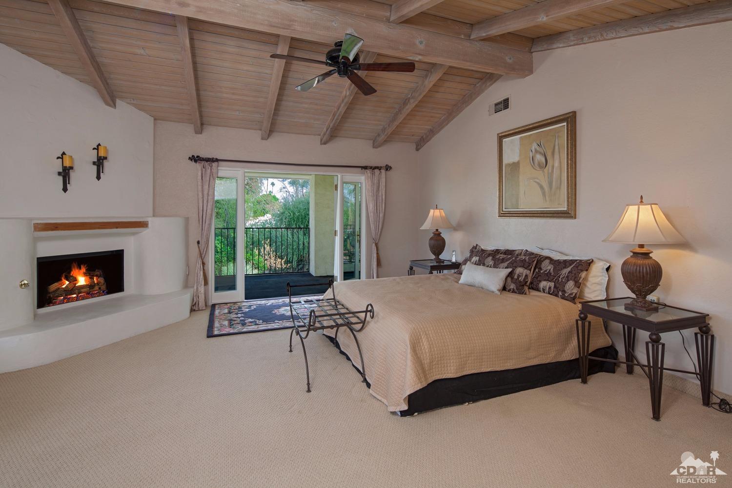 2 Vista Santa Rosa Rancho Mirage, CA 92270 - Photo 33 of 60 a spacious bedroom with a bed a table and a fireplace